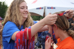 A volunteer presents a medal to a young competitor at the Ironman Kids Fun Run in St. George, Utah, May 6, 2016 | Photo by Don Gilman, St. George News