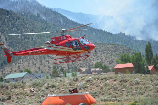 Type 3 (light) helicopter dipping for water to suppress a lightning-caused fire burning on Saddle Mountain in the Pine Valley Wilderness of the Dixie National Forest, Washington County, Utah, June 28, 2016 | Photo courtesy of InciWeb, St. George News