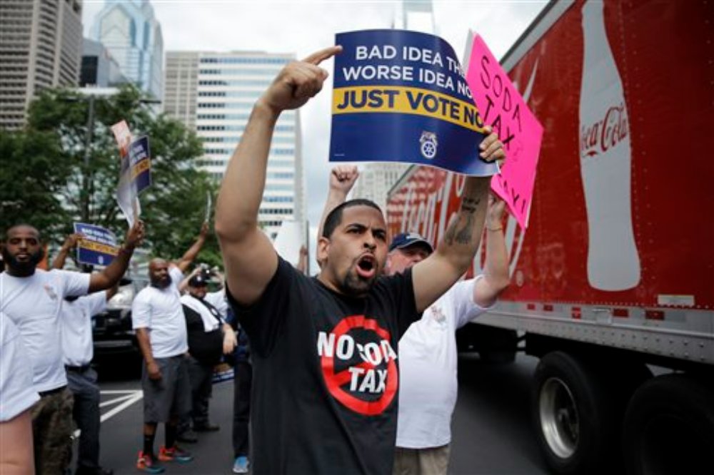 FILE –Opponents of a proposed sugary drink tax demonstrate outside City Hall in Philadelphia. Philadelphia is set to become the first major American city with a soda tax despite a multimillion-dollar campaign by the beverage industry to block it. The City Council is expected to give final approval Thursday, June 16, 2016, to a 1.5 cent-per-ounce tax on sugary and diet beverages, Philadelphia, Pennsylvania, June 8, 2016 | AP Photo/Matt Rourke, File, St. George News 