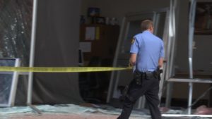 St. George Police Officer Zack Bahlmann runs police tape out after a loose trailer smashed through the Social Security office on North Bluff St. Tuesday. St. George, Utah, June 28, 2016 | Photo by Sheldon Demke, St. George News