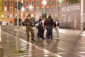 Police officers and a soldier stand by the sealed off area of an attack after a truck drove on the sidewalk and plowed through a crowd of revelers that gathered to watch fireworks in the French resort city of Nice, southern France, Friday, July 15, 2016. | AP Photo/Ciaran Fahey, St. George News)