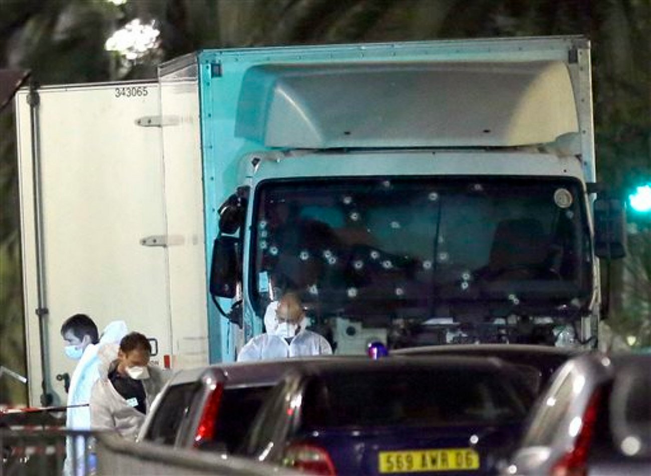 Forensic officers stands near a truck with its windscreen riddled with bullets, that plowed through a crowd of revelers who'd gathered to watch the fireworks in the French resort city of Nice, southern France, Friday, July 15, 2016. At least 80 people were killed before police killed the driver, authorities said, Nice France, July 15, 2016 | AP Photo by Claude Paris, St. George News