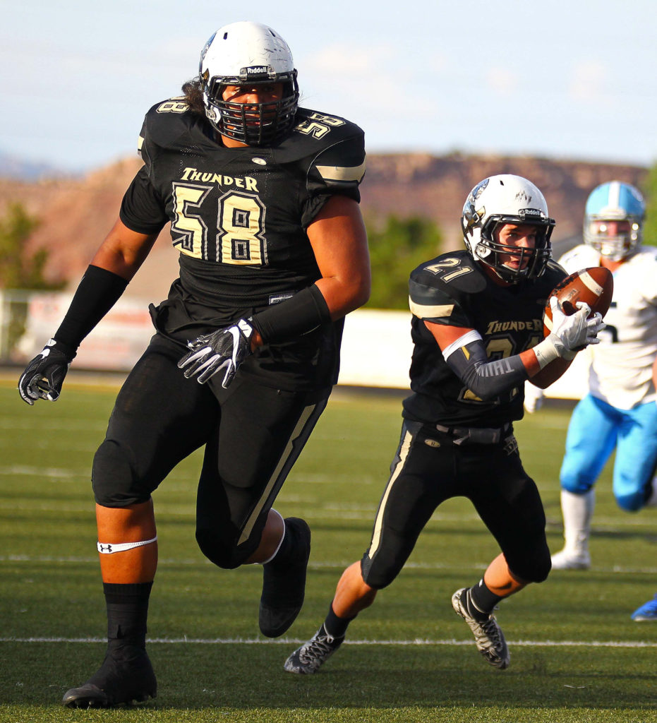 Desert Hills’ Penei Sewell (58) leads the way for Brock Perry (21), Desert Hills vs. Salem Hills, Football, St. George, Utah, Aug. 26, 2016, | Photo by Robert Hoppie, ASPpix.com, St. George News