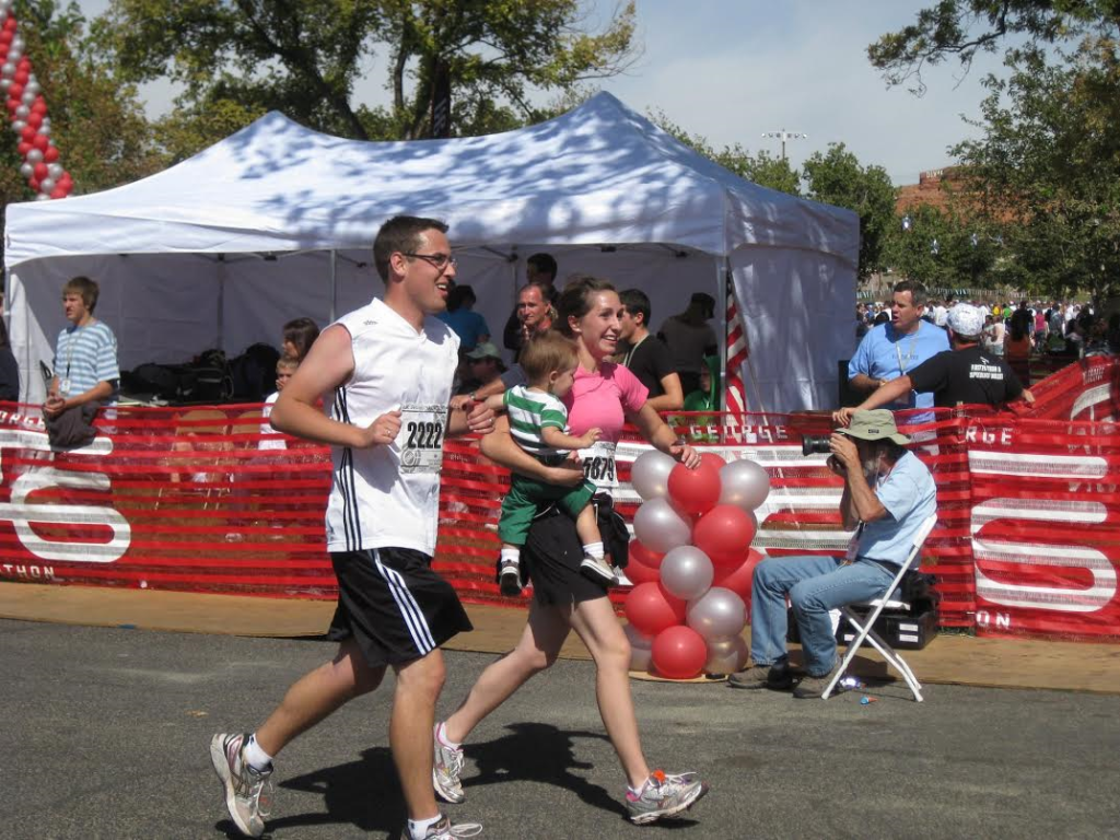 L-R Austin Cope and Laura Cope finish the 2009 St. George Marathon with their young child in arms, St. George Utah, circa October 2009 | Photo courtesy of Laura Cope, St. George News