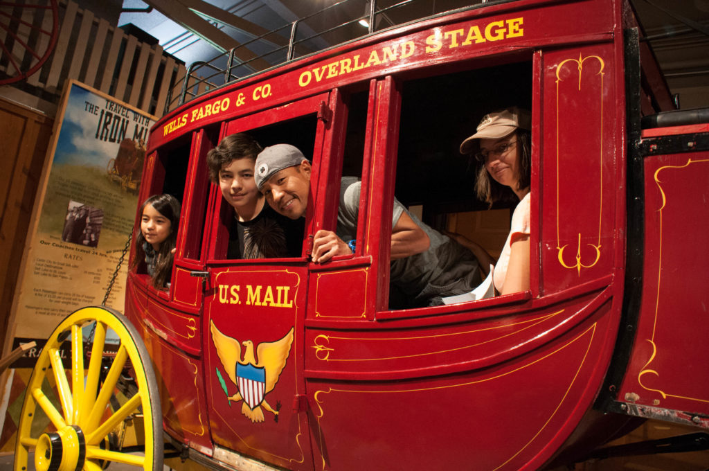 Visitors imagine riding in a stagecoach, Frontier Homestead State Park Museum, Cedar City, Utah, August 2016 | Photo by Kathy Lillywhite, St. George News