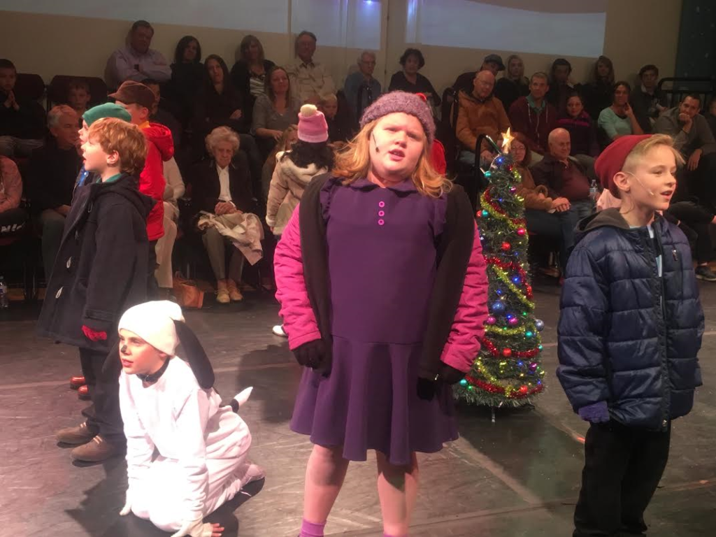 Erika Wright (in purple) as Violet joins the cast of St. George Musical Theater's production of "A Charlie Brown Christmas" in singing Christmas carols at the St. George Opera House, St. George, Utah, Dec. 3, 2016 | Photo by Hollie Reina, St. George News