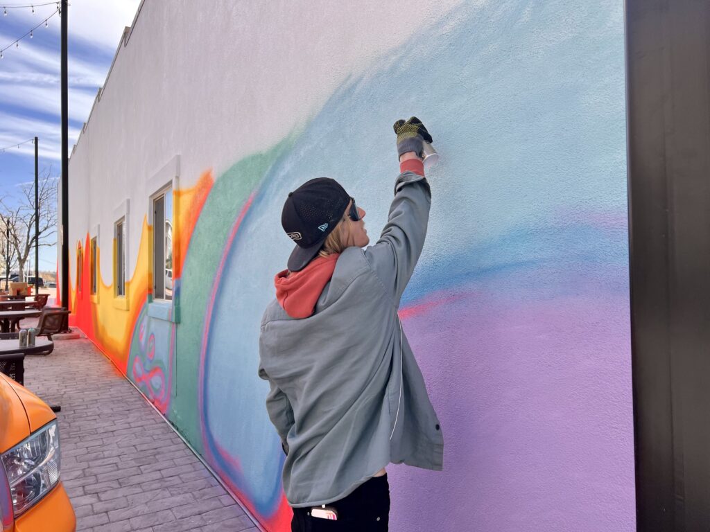 TJ Eisenhart is working on a mural in downtown St. George, Utah, March 22, 2022. Photo courtesy of Jessi Bang, St.  George New
