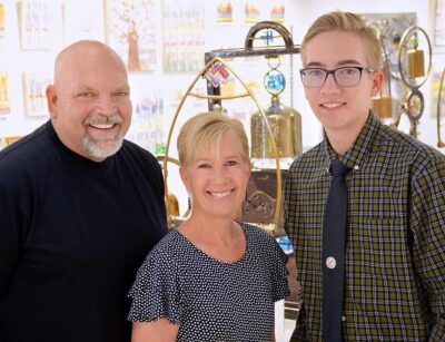 Doug, Dianne and Ryan Adams stand in front of bell sculptures, Date and location unspecified | Photo courtesy of Dianne Adams, St. George News