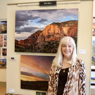 Deborah Bice, former Chairperson for Arrowhead Gallery and current Chair for Washington City Arts Council, stands in front of her photography, St. George, Utah, May 18, 2022 | Photo by Jessi Bang, St. George News
