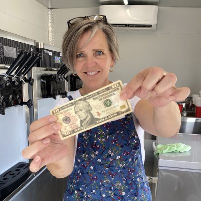 Mary Ludlow shows the first $10.00 bill she received at her new business, We Celebrate, location and date unspecified | Photo courtesy of Mary Ludlow, St. George News