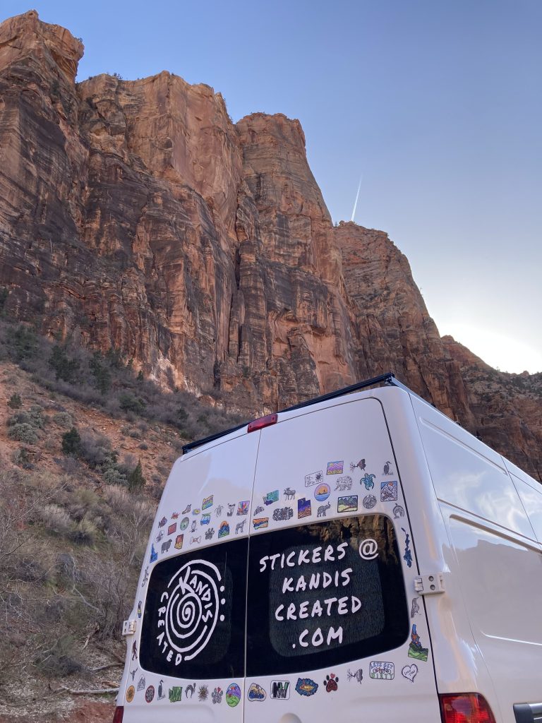 Artist Kandice Larson's van is parked under a red rock. The location and date have not been specified. Photo credit: Kandis Larson, St. George News