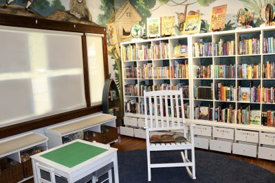 The children's area of the Book Bungalow shows a rocking chair with a wide variety of books, St. George, Utah, July 27, 2022 | Photo by Jessi Bang, St. George News