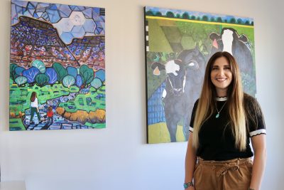 Torie Denning stands next to some of her paintings, Washington, Utah, Sept. 1, 2022 | Photo by Jessi Bang, St. George News