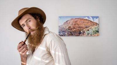 Brady Iverson poses in front of his photograph, location and date unspecified | Photo by Khalob Freeborne courtesy of Brady Iverson, St. George News