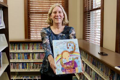 Jana York stands with her book, “U Is for Understanding: Claire's Journey toward Mindfulness” inside the St. George Library, Dec. 1, 2022 | Photo by Jessi Bang, St. George News