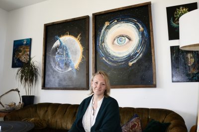 Artist Stephanie Lindhardt poses next to her paintings inside her home in Hurricane, Utah, Jan. 11, 2023 | Photo by Jessi Bang, St. George News