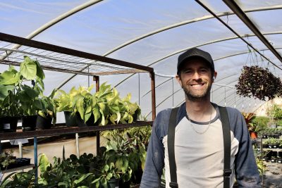 Payton Fisher smiles for the camera inside a greenhouse in Hurricane, Utah on Feb. 21, 2023 | Photo by Jessi Bang, St. George News