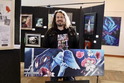 Artist Joaquin Jimenez holds one of his art pieces inside Red Cliffs Gallery in St. George, Utah on March 6, 2023 | Photo by Jessi Bang, St. George News