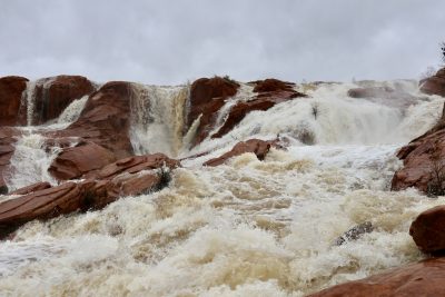 Waterfalls flow down the red rocks at Gunlock State Park in Gunlock, Utah, March 15, 2023 | Photo by Jessi Bang, St. George News