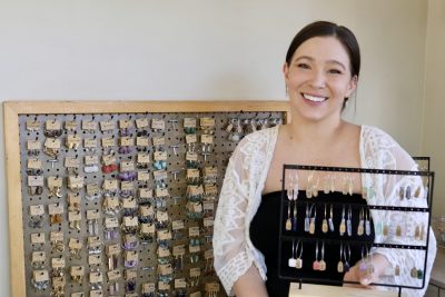 Keelee Brinkerhoff, the owner of Wilde Botanical Company, takes a photo next to her crystal earrings in Santa Clara, Utah, May 2, 2023 | Photo by Jessi Bang, St. George News