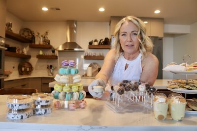 Tammy Elmore, the owner of Tammy's Treats, hands over a toasted coconut macaroon, Hurricane, Utah, May 8, 2023 | Photo by Jessi Bang, St. George News