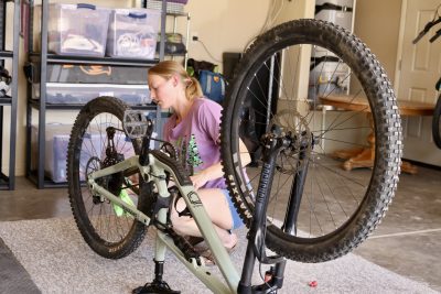Wild Mesa Mountain Bike Guides owner Kelsey Grunigen works on a bike inside her garage in Hurricane, Utah, May 17, 2023 | Photo by Jessi Bang, St. George News