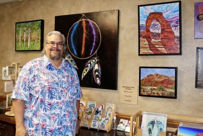 Wil Adams, the artist behind Desert Art Vibe, stands next to his artwork in St. George, Utah, July 19, 2023 | Photo by Jessi Bang, St. George News