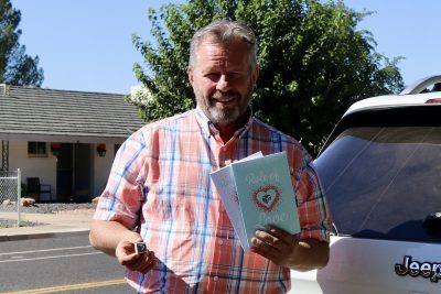 Paul Zolman, owner of Role of Love, takes a photo with his dice, books and journal, St. George, Utah, Sept. 25, 2023 | Photo by Jessi Bang, St. George News
