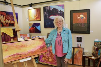 Mary Manning stands next to her artwork, which is on display in a private art gallery inside the Arrowhead Gallery, St. George, Utah, Feb. 28, 2024 | Photo by Jessi Bang, St. George News