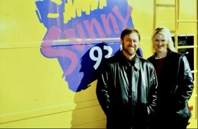 Bryan Benware and Cindy Olson stand in front of the Sunny 93.5 van while hosting a radio show together for over a decade, location and date not specified | Photo courtesy of Cindy Olson, St. George News